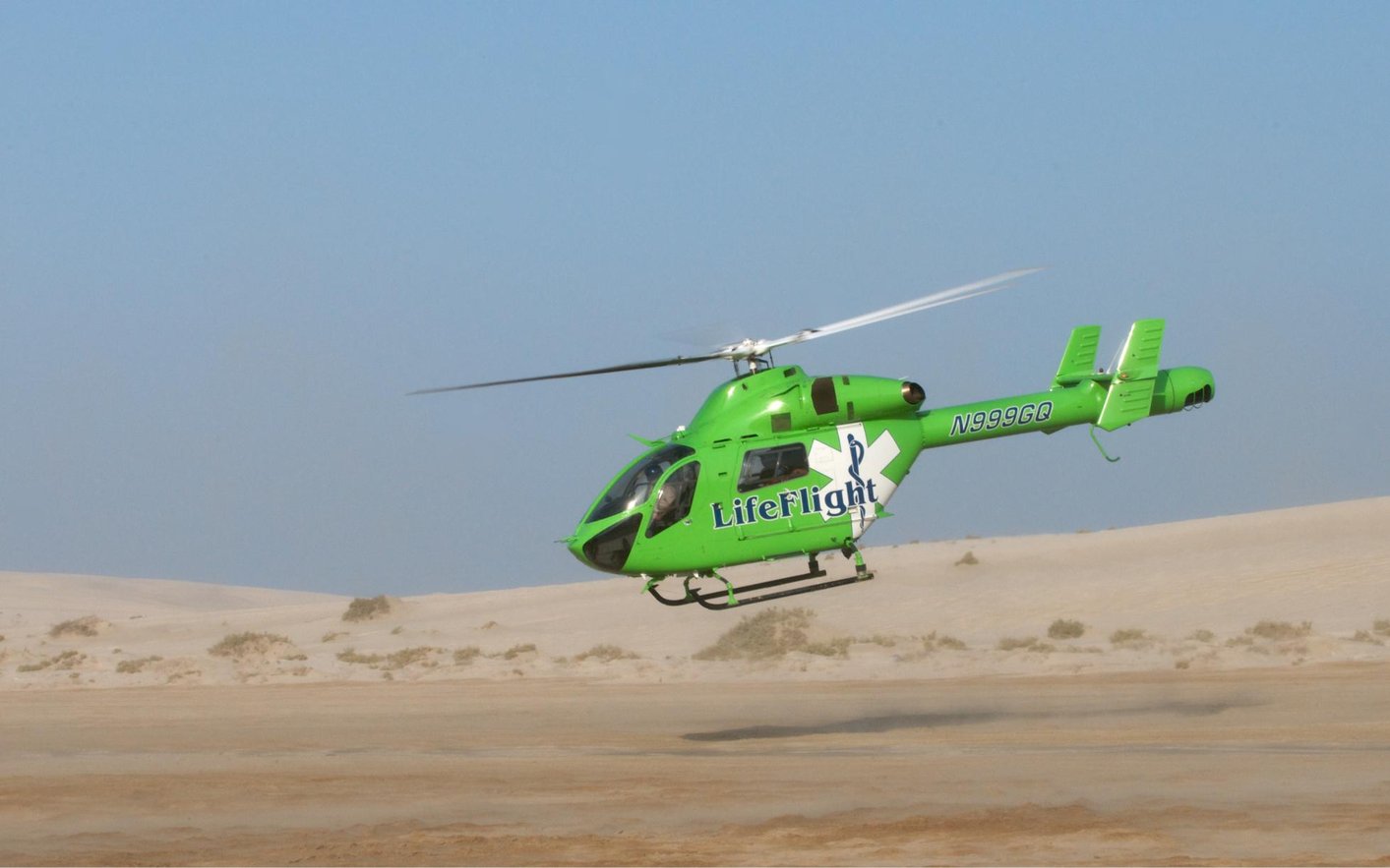 Green MD 902 Explorer air ambulance helicopter in flight